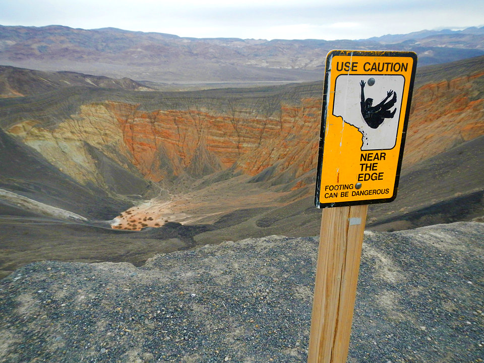 Caution sign. Living on the edge at Ubehebe Crater Caution sign. Living on the edge at Ubehebe Crater